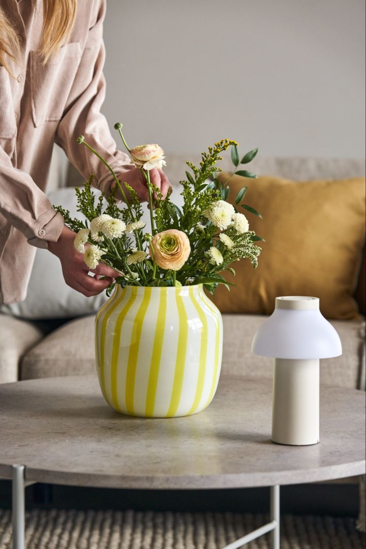 Verschönern Sie Ihr Wohnzimmer mit einem schönen Blumenstrauß in der lebhaften Vase Juice in Gelb von HAY. 