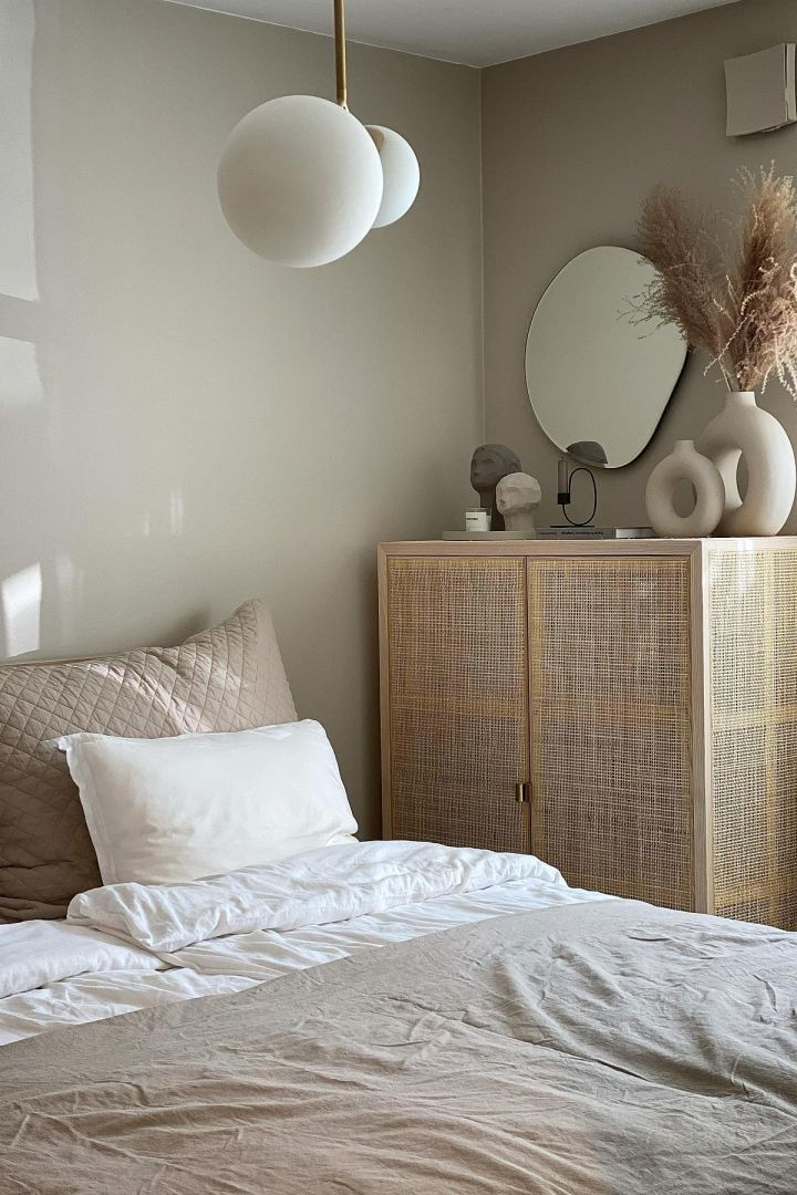 11 stylische Pendelleuchten für Ihr Wohlfühlzuhause - hier sehen Sie die Pendelleuchte Twice von House Doctor, die über einem Bett in einem beigen Schlafzimmer hängt.