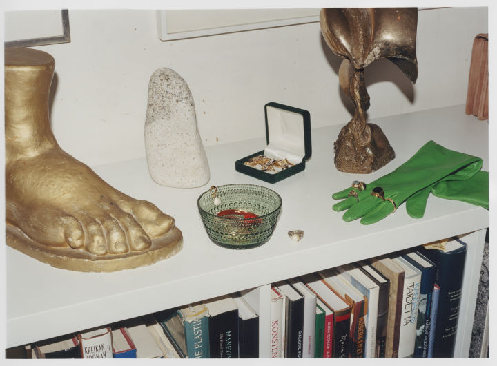 Iittala tritt in eine neue Ära ein, aber die Produkte bleiben dieselben, hier die Kastehelmi-Schale in Grün auf einem Sideboard mit Statuen und Handschuhen. 
